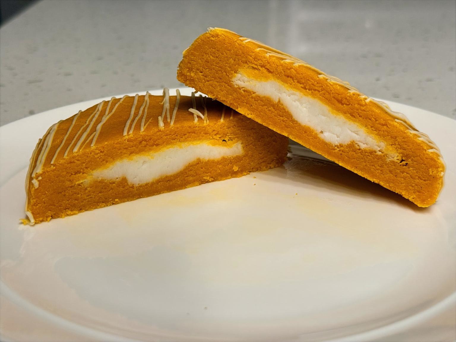 Summer Dreamsicle cookie cut open to show its vanilla buttercream center